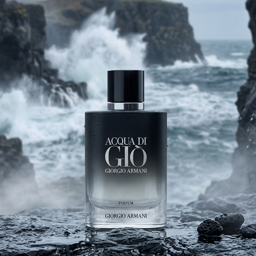 A bottle of Giorgio Armani Acqua Di Gio Parfum stands on dark wet rocks with a dramatic ocean scene of crashing waves and cliffs in the background.